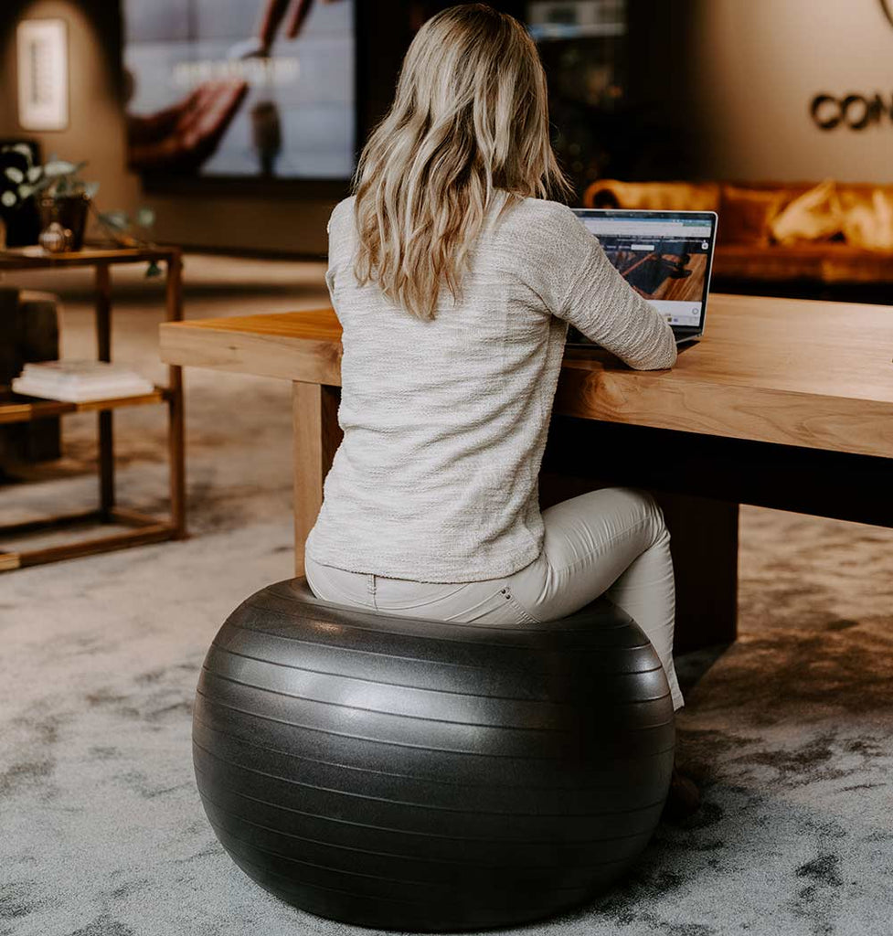 sitting on a pilates ball in the office woman